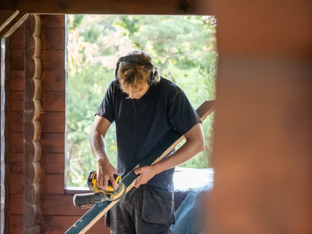 Tømrer måler op i vinduesåbningen i bjælkehuset — billede 1 af 4