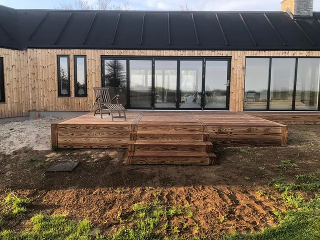 Nybygget sommerhus i lærketræ med sort tag og terrasse — billede 1 af 21