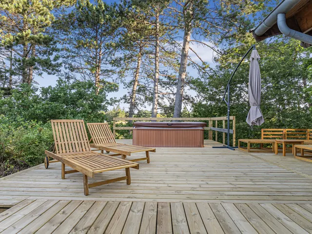 Terrasse i træ med spabad, liggestole og udsigt ved bjælkehus — billede 22 af 30