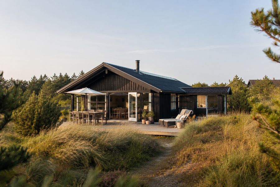 Sort træsommerhus i klitterne