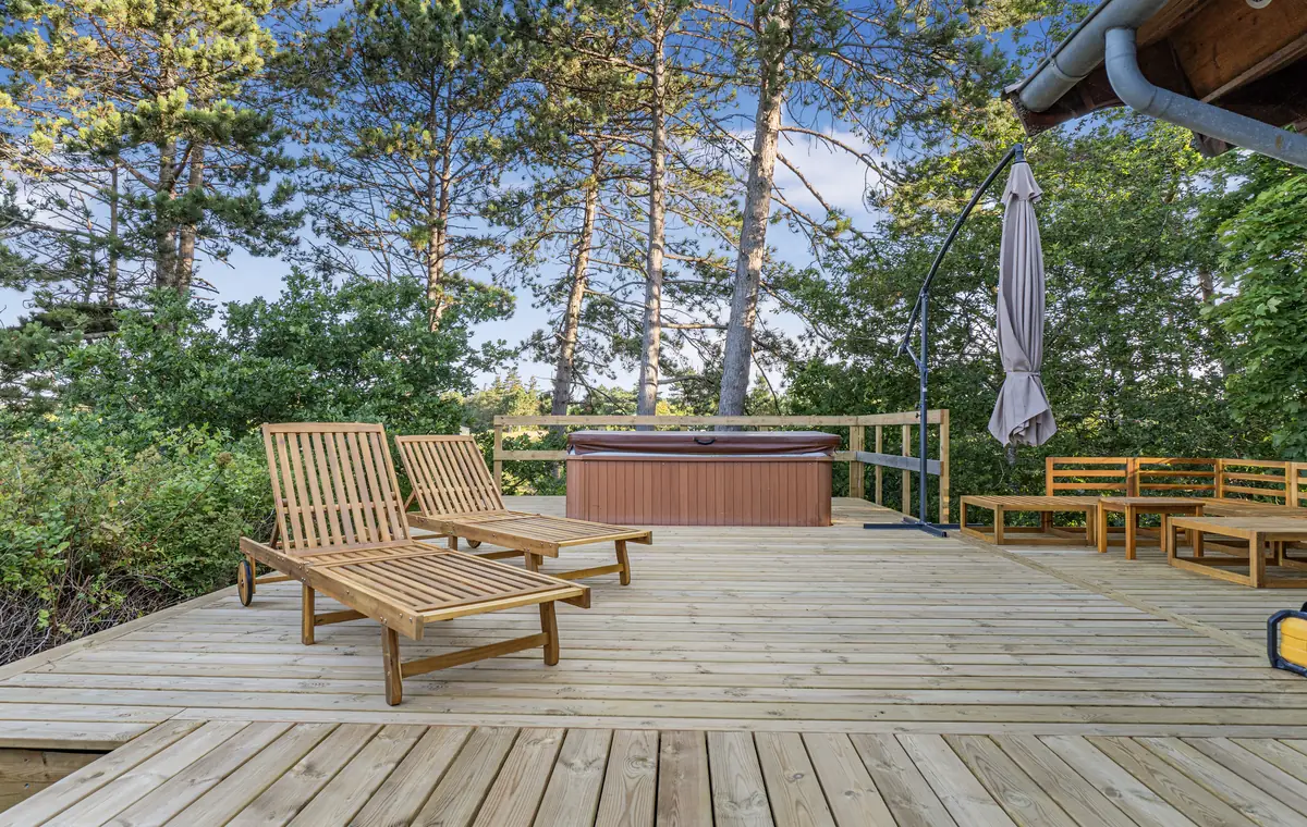 Træterrasse med spabad og liggestole ved sommerhus